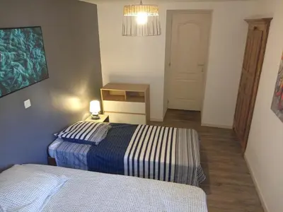 a bedroom with two beds and a table and a lamp at Ravissant appartement au cœur de Piana in Piana