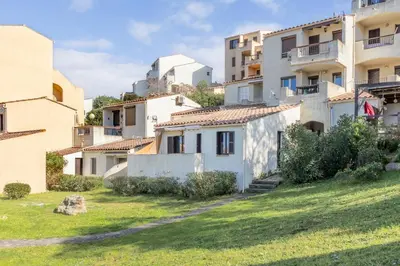 a row of houses in a grassy area with buildings at Azura Prugna - Maison avec piscine partagée in Grosseto-Prugna