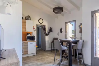 a kitchen and a dining room with a table and chairs at Azura Prugna - Maison avec piscine partagée in Grosseto-Prugna