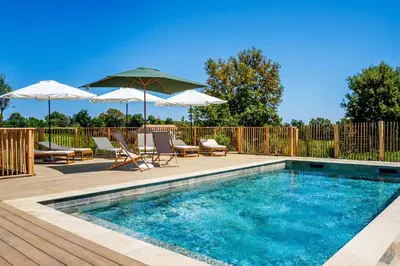 a swimming pool with chairs and umbrellas on a deck at Casamea - Suite U Sognu in Talasani
