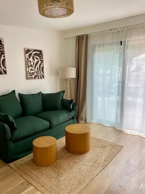 a living room with a green couch and two tables at Caseddu 100m de la plage in Belvédère