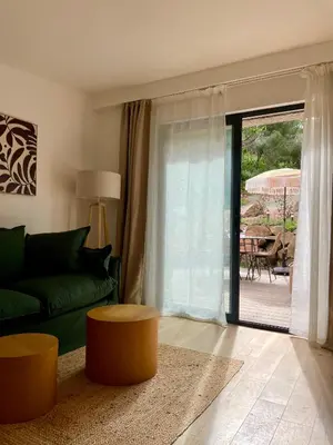 a living room with a green couch and a table at Caseddu 100m de la plage in Belvédère