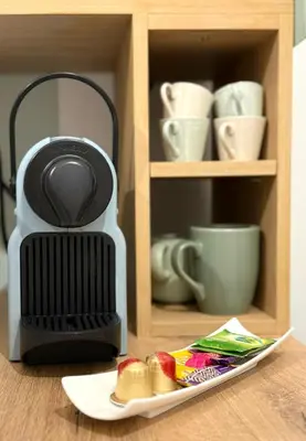 a coffee maker sitting on a table with a plate of food at Le cocon du Roi Jérôme - Hypercentre in Ajaccio