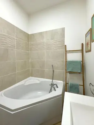 a white bath tub in a bathroom with a sink at Le cocon du Roi Jérôme - Hypercentre in Ajaccio