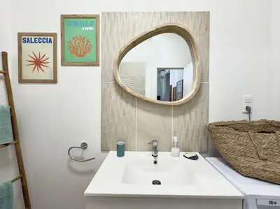 a bathroom with a white sink and a mirror at Le cocon du Roi Jérôme - Hypercentre in Ajaccio