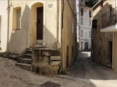 an alley with a door and stairs in a building at Appartement départ GR20 in Calenzana