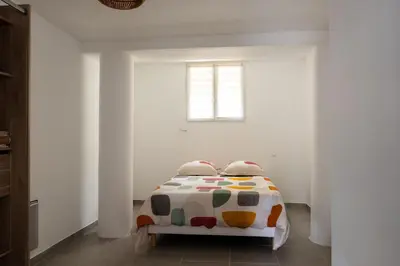 a bedroom with a bed in a white room at Appartement départ GR20 in Calenzana