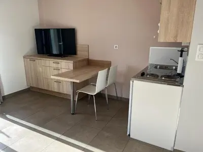 a kitchen with a table and a tv on a counter at Studio 1 avec piscine & vue sur la baie d'Ajaccio in Alata