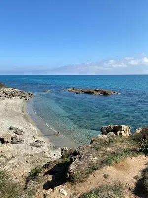 a beach with blue water and rocks in the ocean at T2 VUE MER CORSE N193 in Linguizzetta