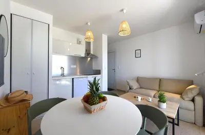 a living room with a white table and a couch at T2 VUE MER CORSE N193 in Linguizzetta