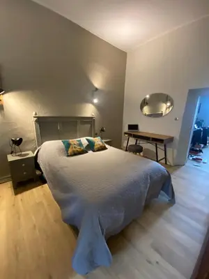 a bedroom with a large bed and a table at T2 Paisible et cosy in Sollacaro