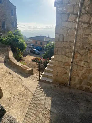 a set of stairs leading up to a stone building at T2 Paisible et cosy in Sollacaro