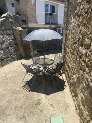 a table with two chairs and an umbrella at T2 Paisible et cosy in Sollacaro