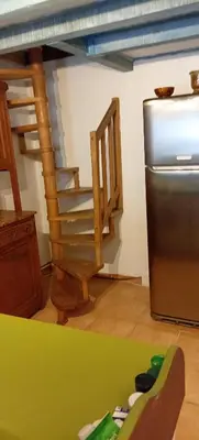 a kitchen with a refrigerator and a stair case at NIOLU in Albertacce