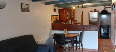 a kitchen with a table and chairs and a couch at NIOLU in Albertacce