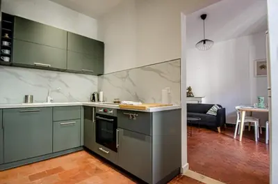 a kitchen with green cabinets and a living room at Casamea - Famille, 2 chambres, Centre , Calme in Ajaccio