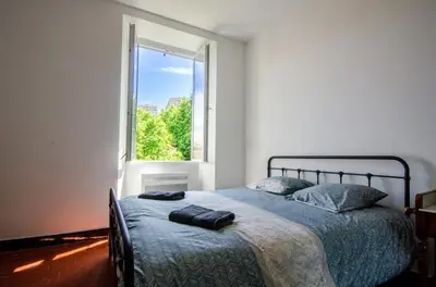 a bedroom with a bed with a large window at Casamea - Famille, 2 chambres, Centre , Calme in Ajaccio