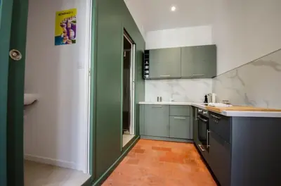 a kitchen with green and white walls and counters at Casamea - Famille, 2 chambres, Centre , Calme in Ajaccio