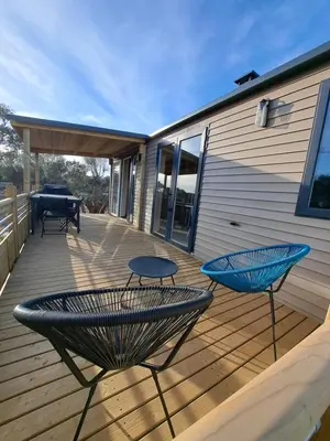 a patio with two chairs and a table on a deck at Chalet n * 1 au cœur du maquis in Bonifacio