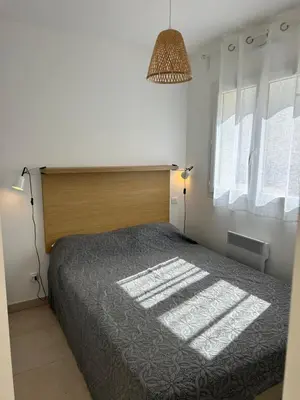 a bedroom with a large bed and a window at Bravone 74- piscine en résidence-clim-wifi-pieds dans l'eau in Linguizzetta