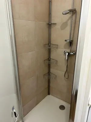 a shower in a bathroom with a glass door at Bravone 74- piscine en résidence-clim-wifi-pieds dans l'eau in Linguizzetta