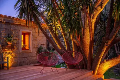 two chairs sitting on a deck next to a tree at I Carbonni - Bergerie 80m2 entre mer et montagne in Sotta