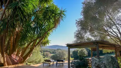 a wooden deck with a table and chairs and trees at I Carbonni - Bergerie 80m2 entre mer et montagne in Sotta