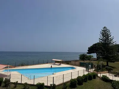 a large swimming pool with the ocean in the background at Appartement n 302 moriani plage in Moriani Plage