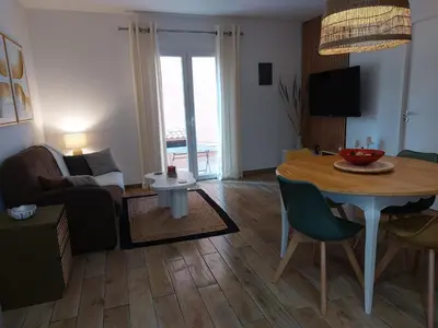 a living room with a table and a couch at Palmeraie102 in Sari Solenzara