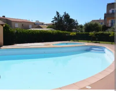 a large swimming pool in a yard at Palmeraie102 in Sari Solenzara