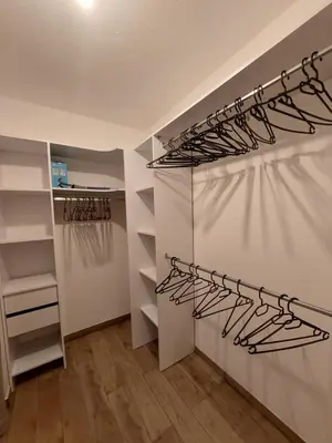 a walk in closet with white walls and shelves at Palmeraie102 in Sari Solenzara