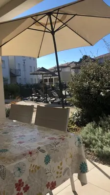 a table with an umbrella on a patio at Appart. en Corse t3 bord de mer et piscine. N 143 in Linguizzetta