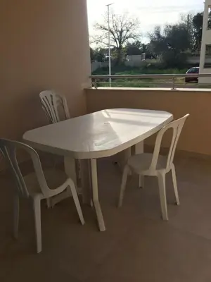 a white table and two chairs on a balcony at Appartement à Ghisonaccia-Prunelli in Prunelli-di-Fiumorbo
