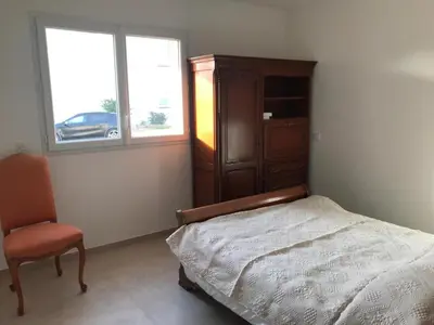 a bedroom with a bed and a dresser and a chair at Appartement à Ghisonaccia-Prunelli in Prunelli-di-Fiumorbo