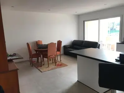 a living room with a table and chairs and a couch at Appartement à Ghisonaccia-Prunelli in Prunelli-di-Fiumorbo