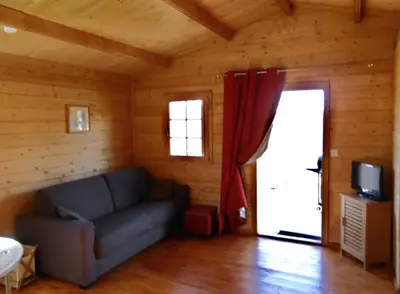 a living room with a couch and a door at Les Chalets De Lozzi in Calacuccia