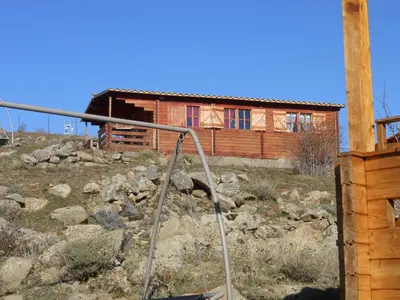 a house on a hill with a gate in front at Les Chalets De Lozzi in Calacuccia