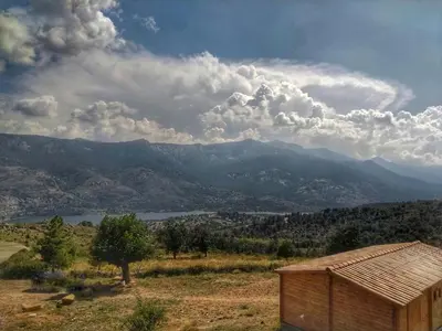 a building in a field with a view of a mountain at Les Chalets De Lozzi in Calacuccia