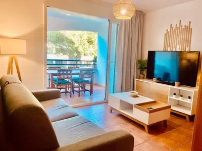 a living room with a couch and a flat screen tv at Appartement en bord de mer avec piscine in San-Nicolao