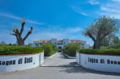a building with a gate in front of a driveway at Appartement en bord de mer avec piscine in San-Nicolao