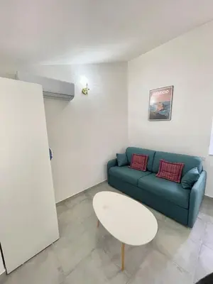 a living room with a blue couch and a white table at Studio 2 Personnes Plein Centre Rue Piétonne in Ajaccio