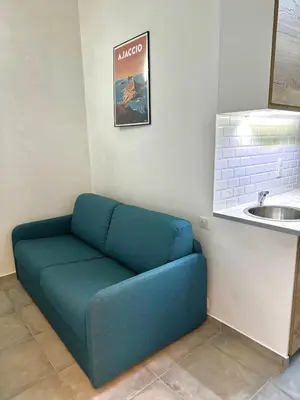 a blue couch in a room next to a sink at Studio 2 Personnes Plein Centre Rue Piétonne in Ajaccio