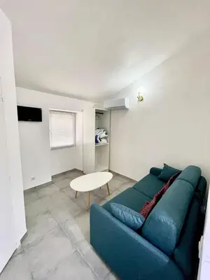 a living room with a blue couch and a table at Studio 2 Personnes Plein Centre Rue Piétonne in Ajaccio