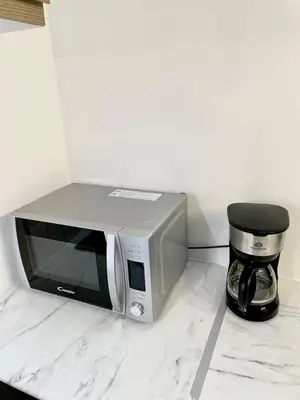 a microwave sitting on a counter next to a coffeeinder at Studio 2 Personnes Plein Centre Rue Piétonne in Ajaccio