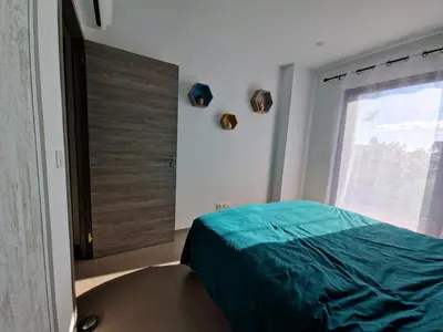 a bedroom with a bed and a large window at Villa ALVALMAX in Porto-Vecchio