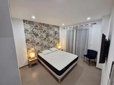 a bedroom with a bed and a tv and a chair at Villa ALVALMAX in Porto-Vecchio