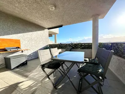 a patio with a table and chairs on a balcony at Appartement ALERIA 2/4 personnes in Aléria