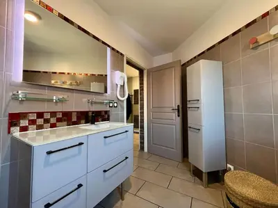 a kitchen with white cabinets and a refrigerator at Appartement ALERIA 2/4 personnes in Aléria