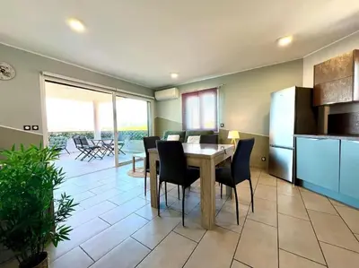 a kitchen and dining room with a table and chairs at Appartement ALERIA 2/4 personnes in Aléria