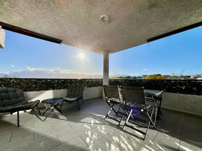 a patio with chairs and a table on a balcony at Appartement ALERIA 2/4 personnes in Aléria